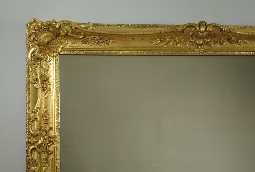 A large rectangular Victorian giltwood wall mirror featuring an ornate swept frame with shell and scroll corner mouldings. View III