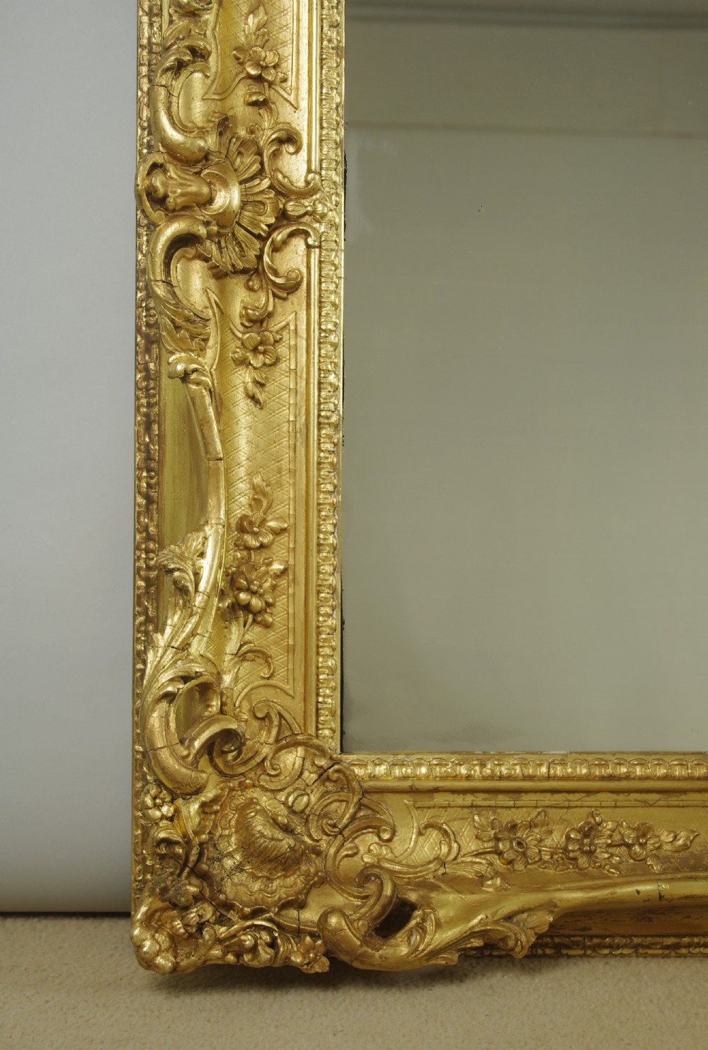 A large rectangular Victorian giltwood wall mirror featuring an ornate swept frame with shell and scroll corner mouldings. View VI