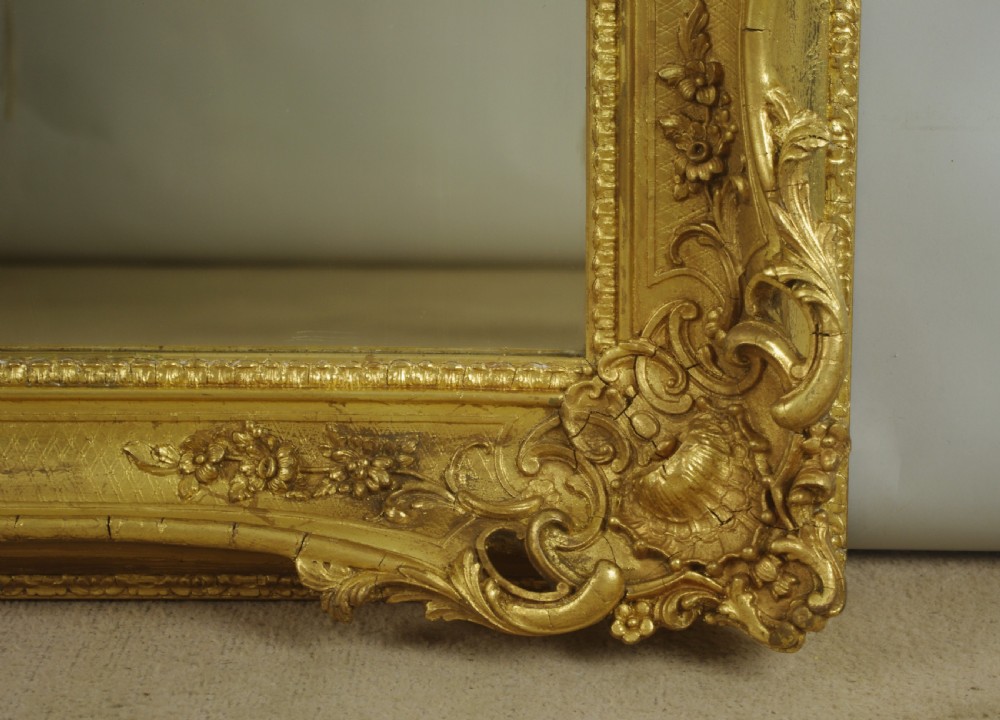 A large rectangular Victorian giltwood wall mirror featuring an ornate swept frame with shell and scroll corner mouldings. View VII