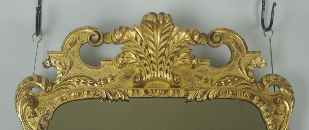 A rectangular 19th-century giltwood wall mirror featuring carved acanthus leaf cresting and scroll details in an aged gold finish. View III
