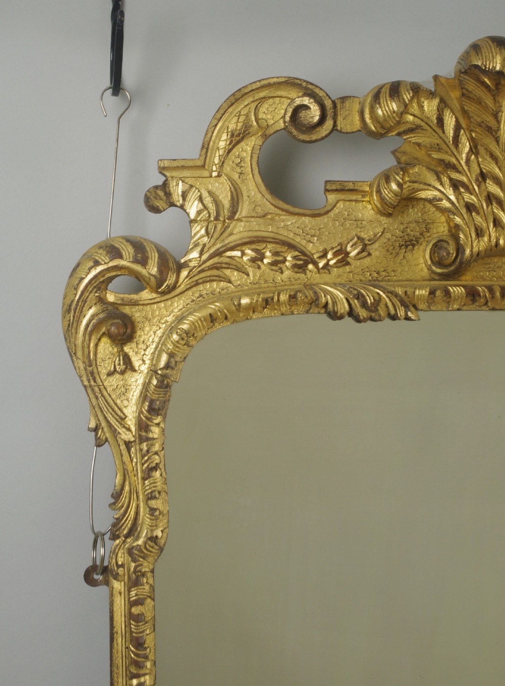 A rectangular 19th-century giltwood wall mirror featuring carved acanthus leaf cresting and scroll details in an aged gold finish. View IV
