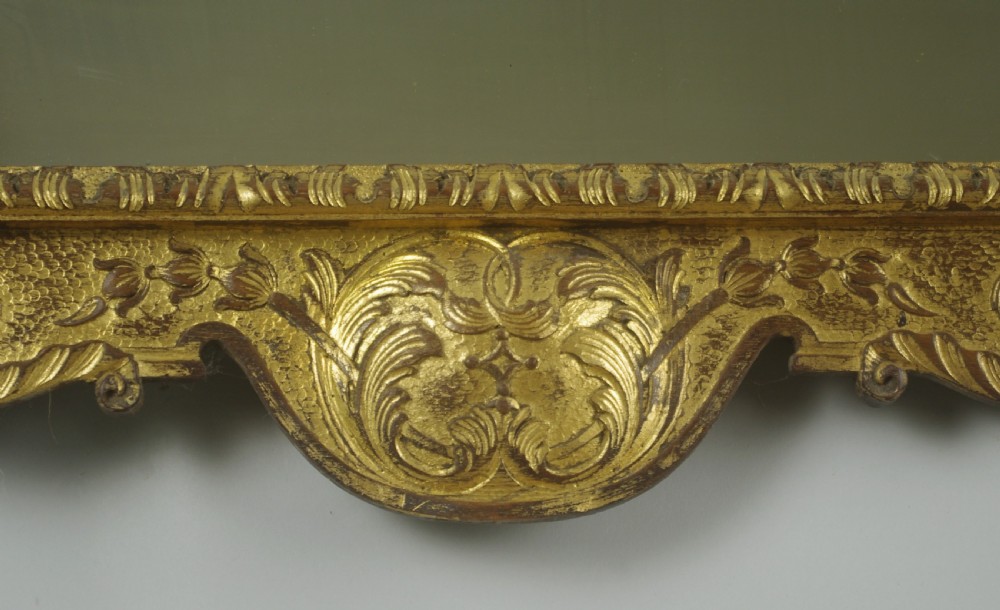 A rectangular 19th-century giltwood wall mirror featuring carved acanthus leaf cresting and scroll details in an aged gold finish. View VII