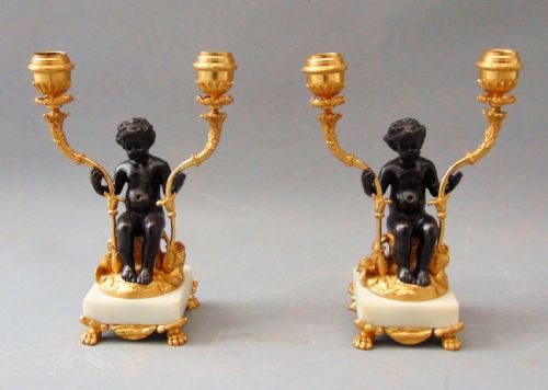 A Pair of Bronze and Ormolu Cherub Candlesticks