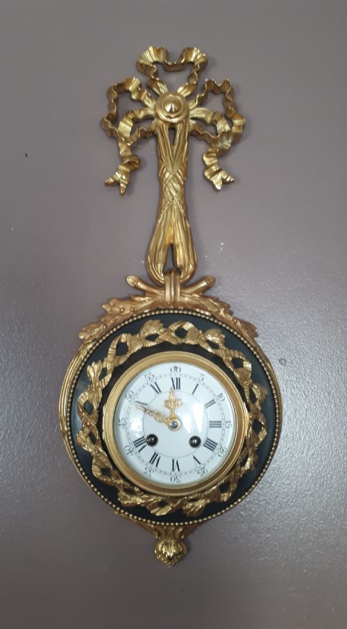 A Gilt and Bronze Cartel Ribbon Clock