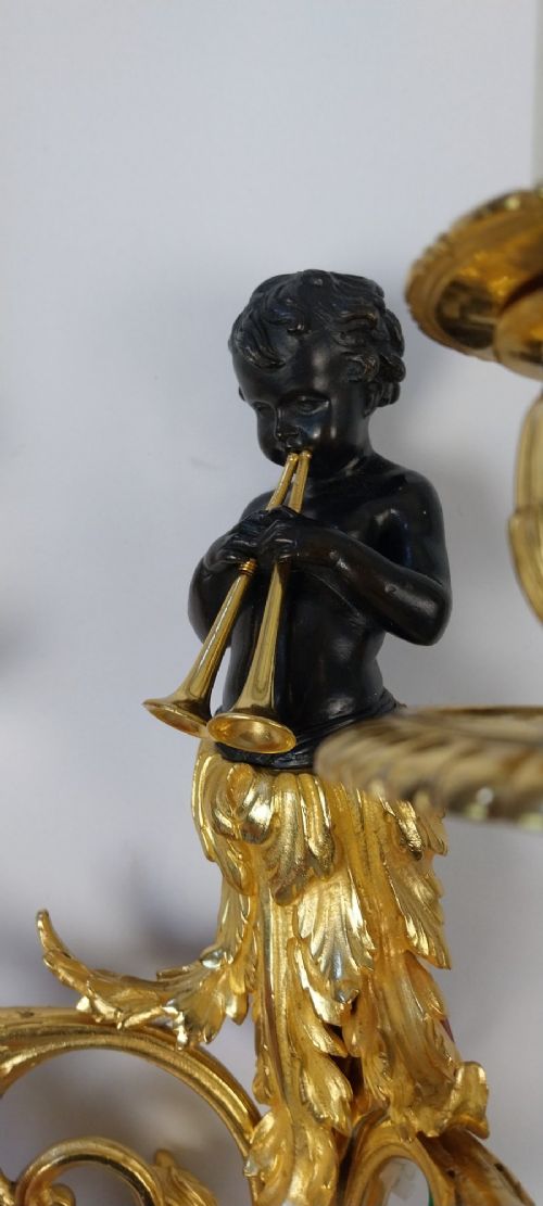 A pair of French gilt and dark patinated bronze two-branch wall sconces featuring central figures holding musical instruments. View III