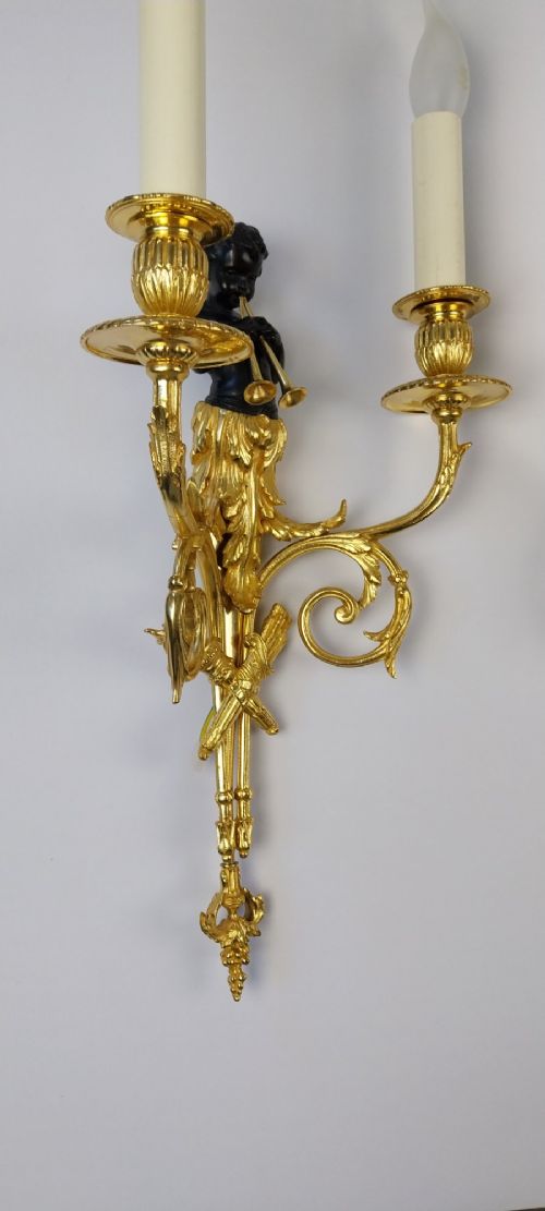 A pair of French gilt and dark patinated bronze two-branch wall sconces featuring central figures holding musical instruments. View V
