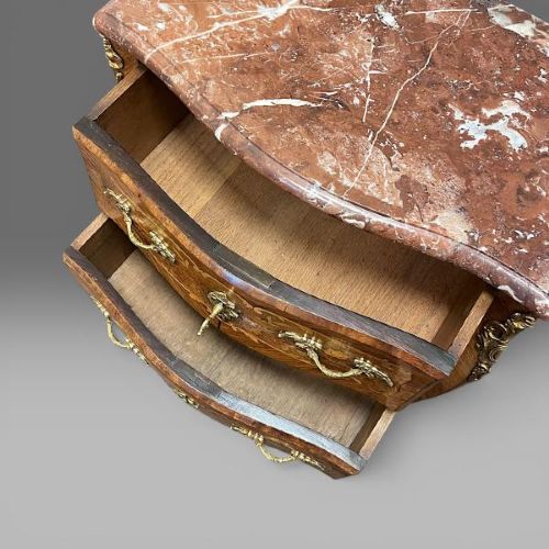 A French Louis XV style bombe commode featuring floral marquetry inlays, gilt bronze mounts, two drawers, cabriole legs, and a red marble top. View IV