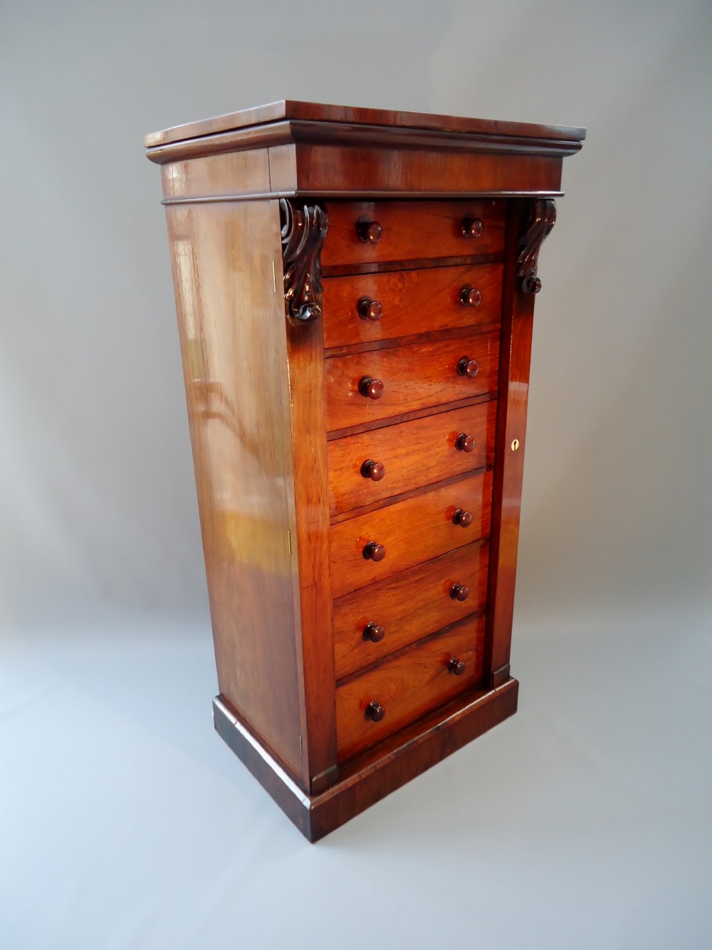 A rose wood wellington chest of drawers