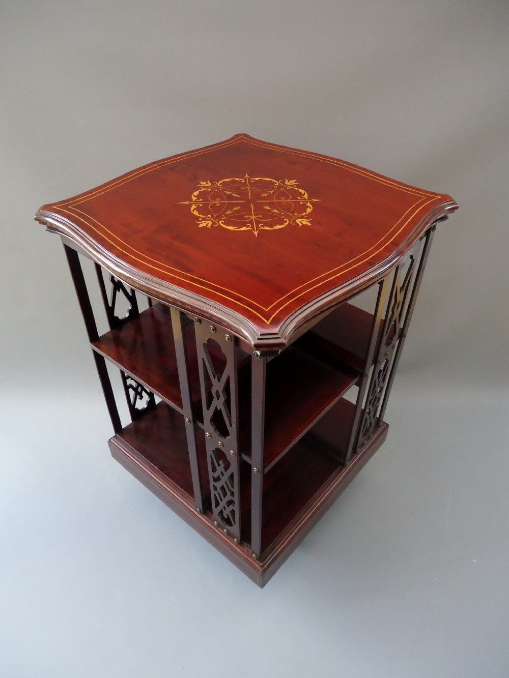 A serpentine shaped mahogany revolving bookcase