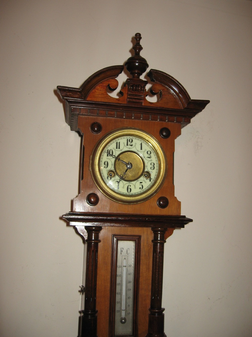 A late Victorian carved wooden wall clock featuring an upper clock face, a central thermometer, and a lower barometer dial. View III