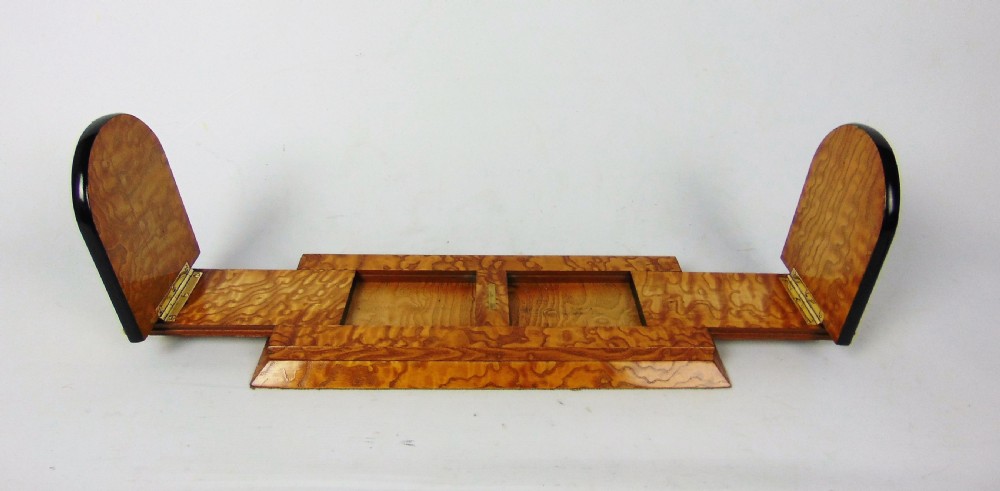 An expanding wooden book slide featuring golden burr wood veneer, folding arched ends, and a gilt brass front plate framing an oval painted porcelain cherub medallion. View III