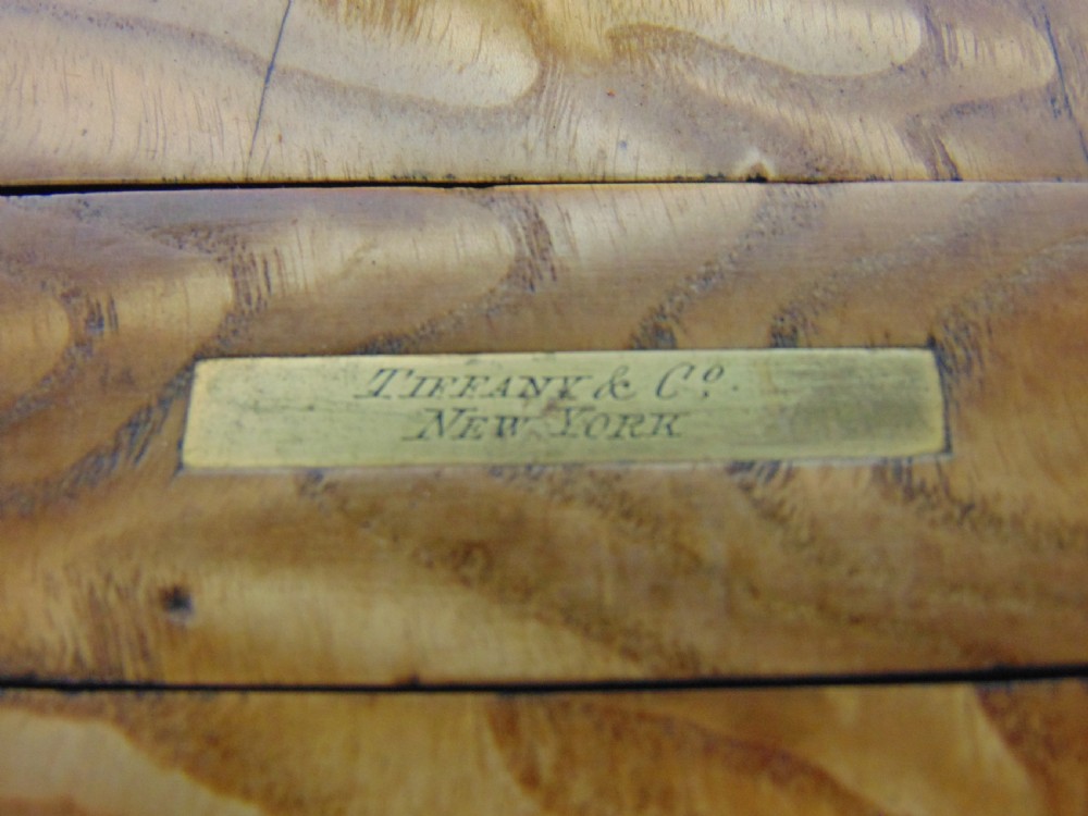 An expanding wooden book slide featuring golden burr wood veneer, folding arched ends, and a gilt brass front plate framing an oval painted porcelain cherub medallion. View VI