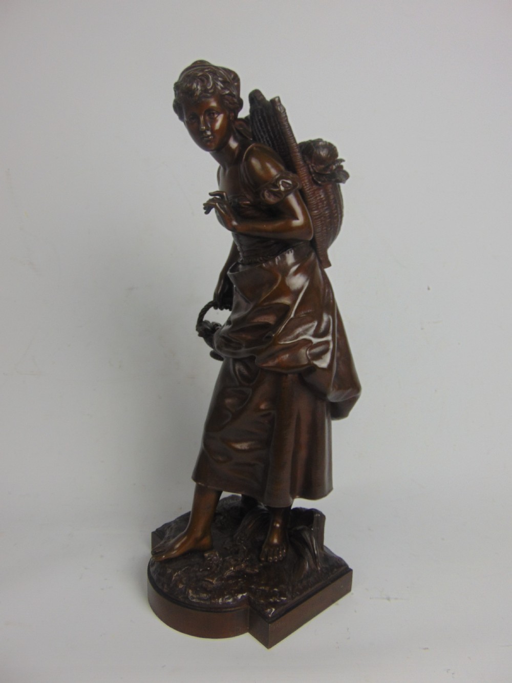 A large bronze bare footed girl collecting eggs View III