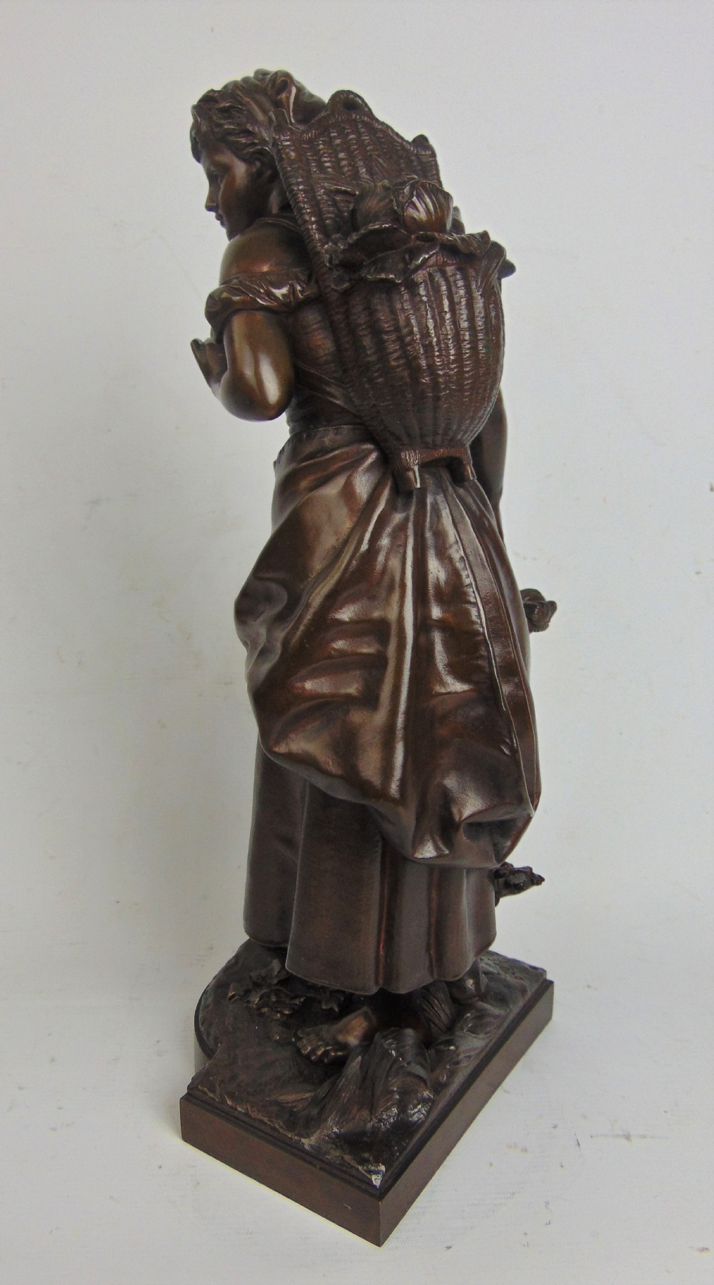 A large bronze bare footed girl collecting eggs View IV