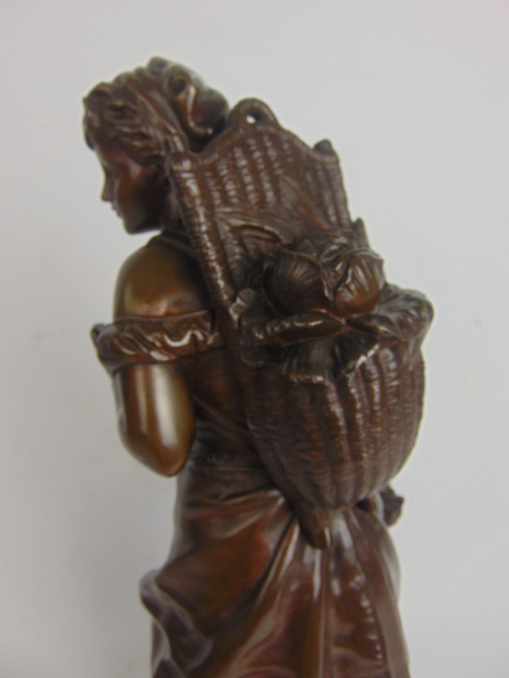 A large bronze bare footed girl collecting eggs View V