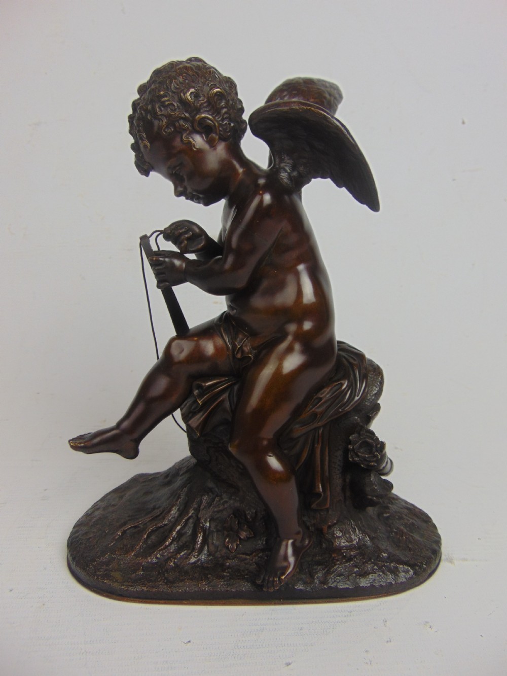 A Bronze Cupid stringing his bow 