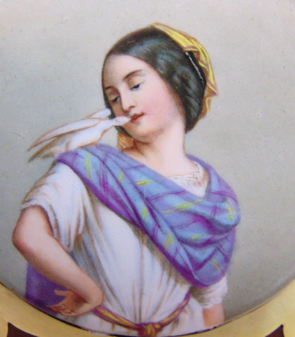 An antique burr walnut book slide featuring pierced brass strapwork with cut-out motifs and two inset circular porcelain plaques painted with female portraits. View IV