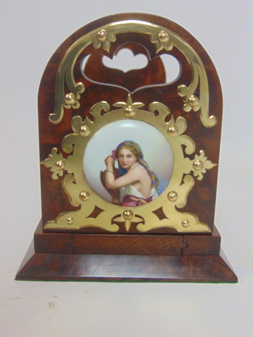 An antique burr walnut book slide featuring pierced brass strapwork with cut-out motifs and two inset circular porcelain plaques painted with female portraits. View V