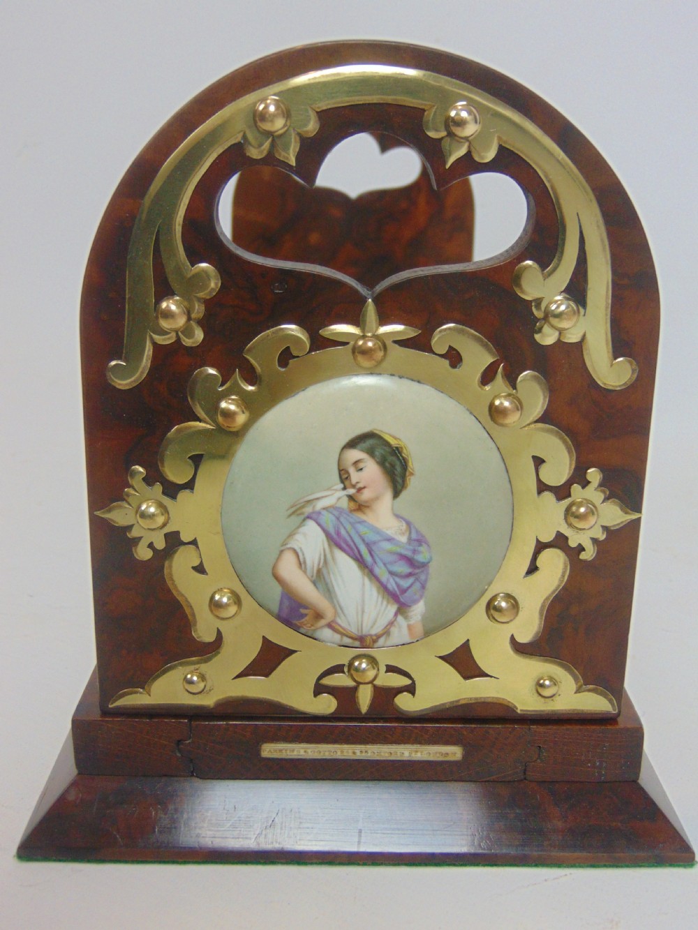 An antique burr walnut book slide featuring pierced brass strapwork with cut-out motifs and two inset circular porcelain plaques painted with female portraits. View VI