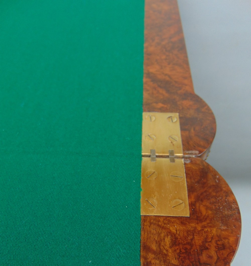 A Victorian burr walnut fold-over card table featuring a figured veneer top, brass beaded edging, and turned fluted legs. View X