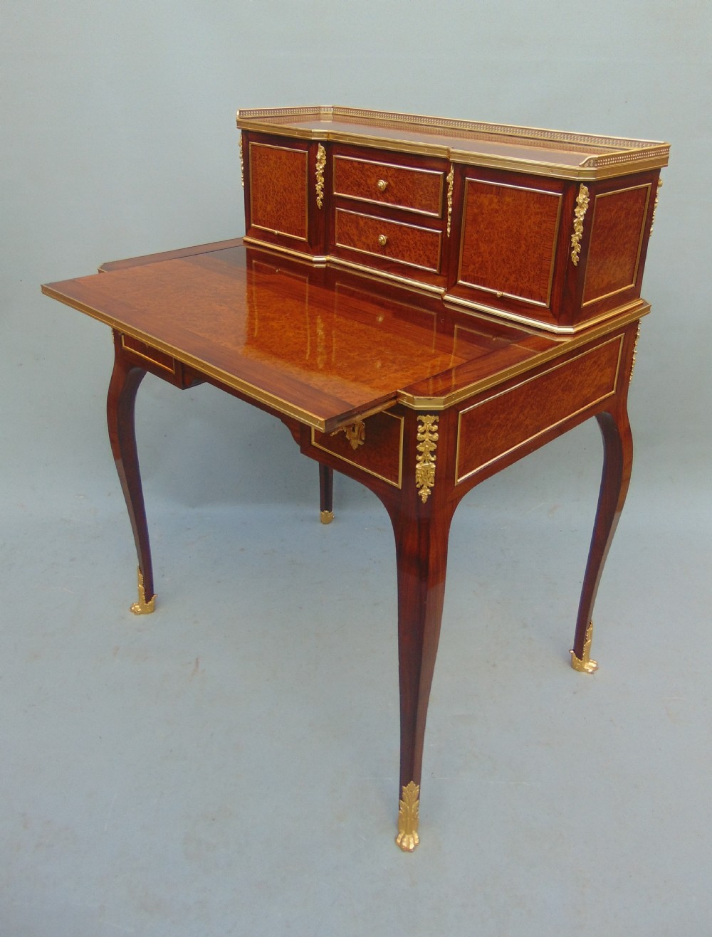 A nineteenth-century French writing desk featuring burr wood veneers, gilt bronze mounts, cabriole legs, and a raised superstructure with small drawers. View III