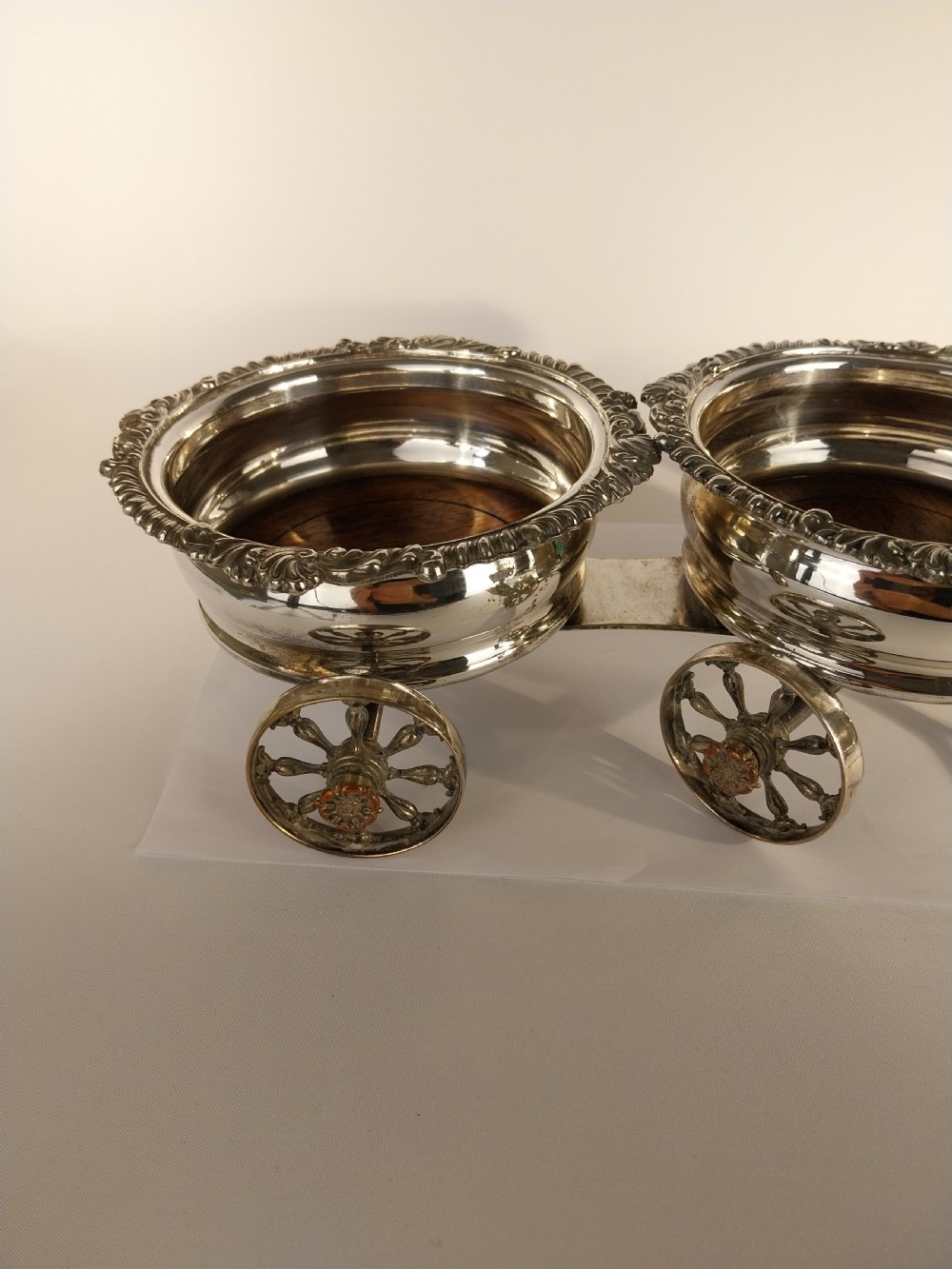 Victorian silver-plated double wine bottle trolley featuring two gadrooned coasters mounted on a wheeled frame with a long handle. View III