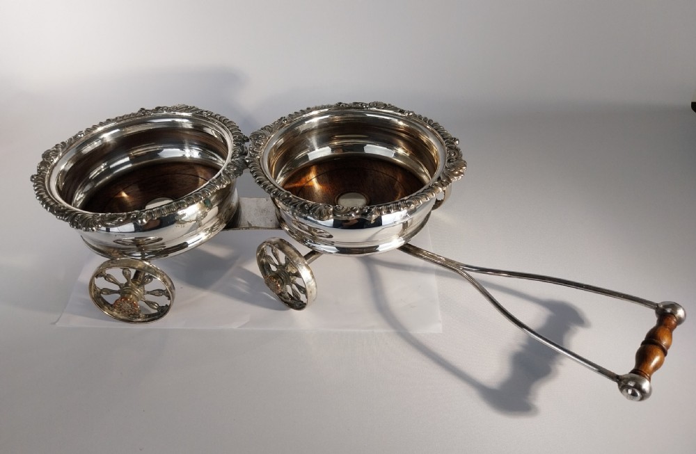 Victorian silver-plated double wine bottle trolley featuring two gadrooned coasters mounted on a wheeled frame with a long handle. View VII