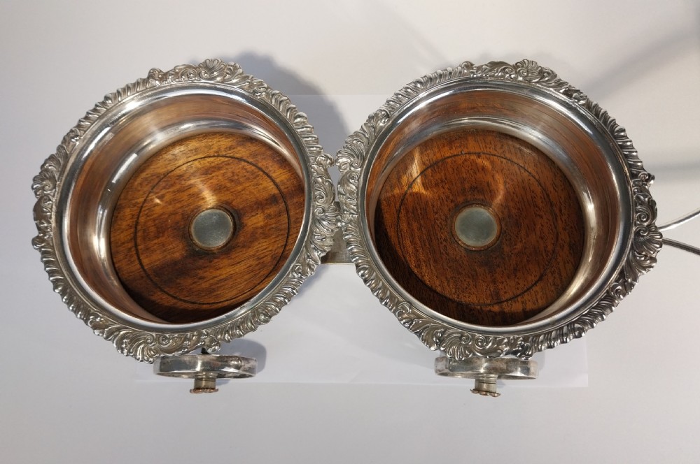 Victorian silver-plated double wine bottle trolley featuring two gadrooned coasters mounted on a wheeled frame with a long handle. View X