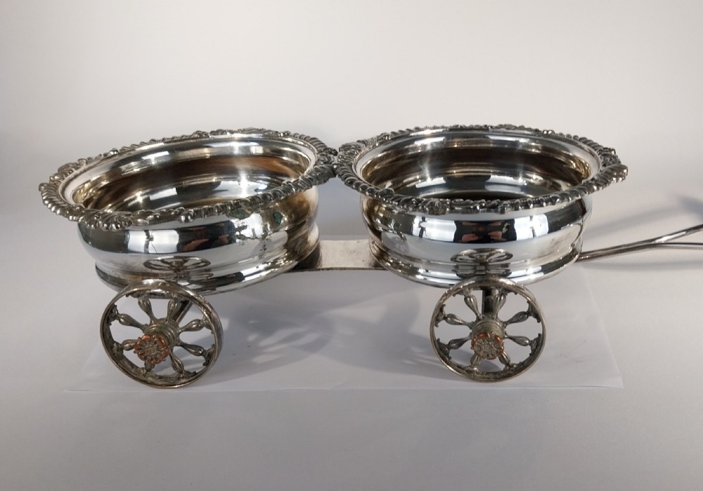 Victorian silver-plated double wine bottle trolley featuring two gadrooned coasters mounted on a wheeled frame with a long handle. View XI