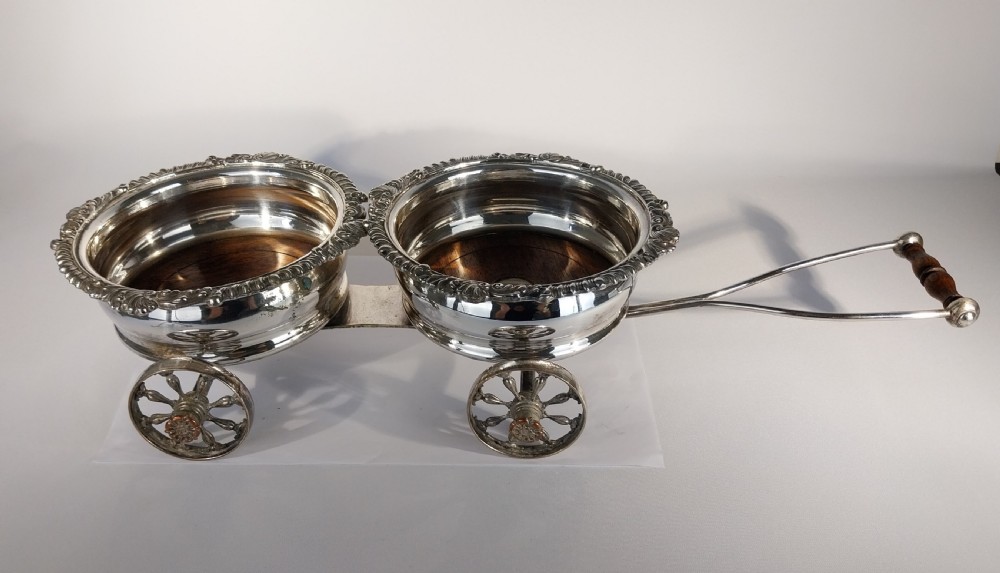 Victorian silver-plated double wine bottle trolley featuring two gadrooned coasters mounted on a wheeled frame with a long handle. View XIII