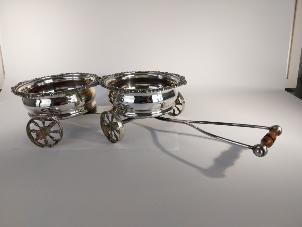 Victorian silver-plated double wine bottle trolley featuring two gadrooned coasters mounted on a wheeled frame with a long handle. View XVII