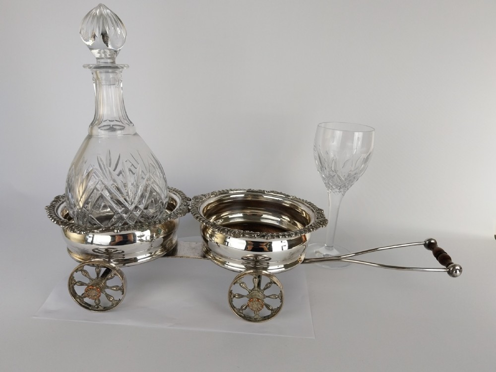 Victorian silver-plated double wine bottle trolley featuring two gadrooned coasters mounted on a wheeled frame with a long handle. View XIX