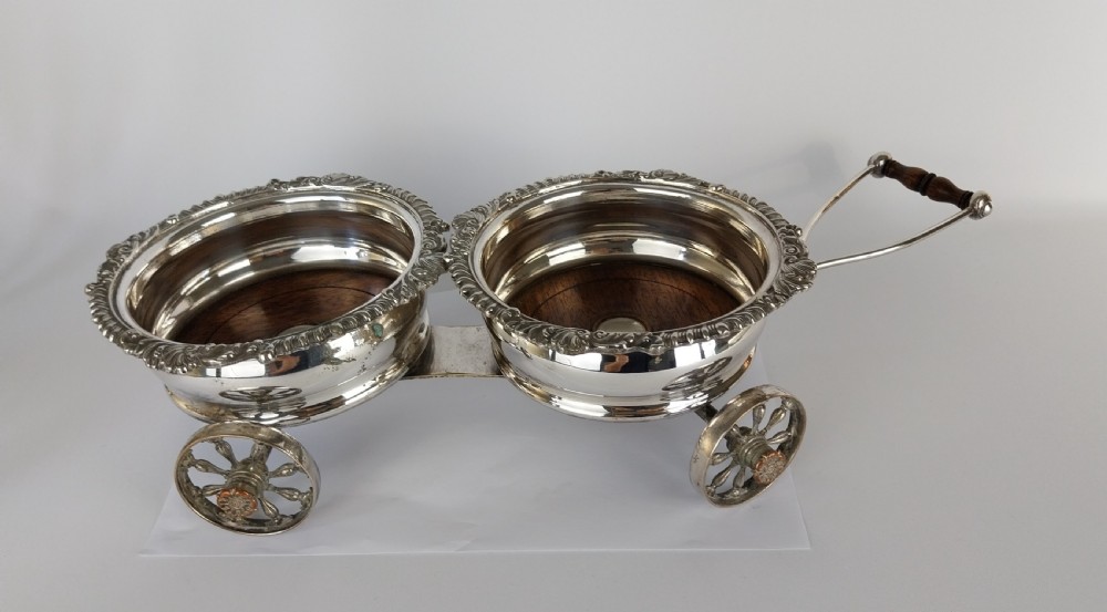 Victorian silver-plated double wine bottle trolley featuring two gadrooned coasters mounted on a wheeled frame with a long handle. View XXIV