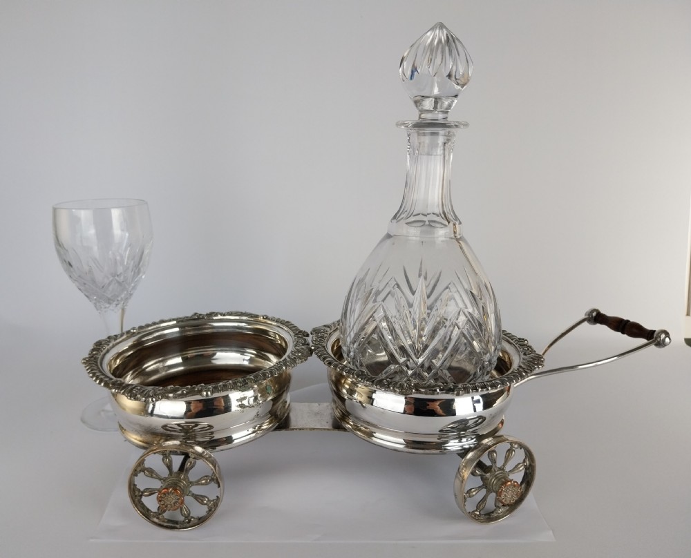 Victorian silver-plated double wine bottle trolley featuring two gadrooned coasters mounted on a wheeled frame with a long handle. View XXV