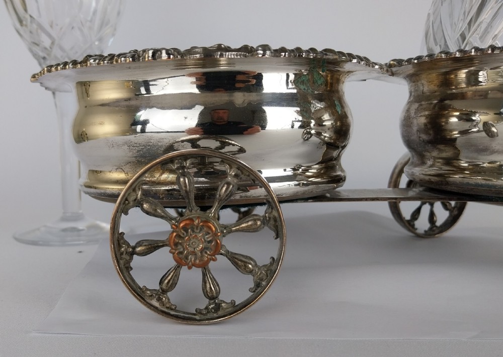 Victorian silver-plated double wine bottle trolley featuring two gadrooned coasters mounted on a wheeled frame with a long handle. View XXVI