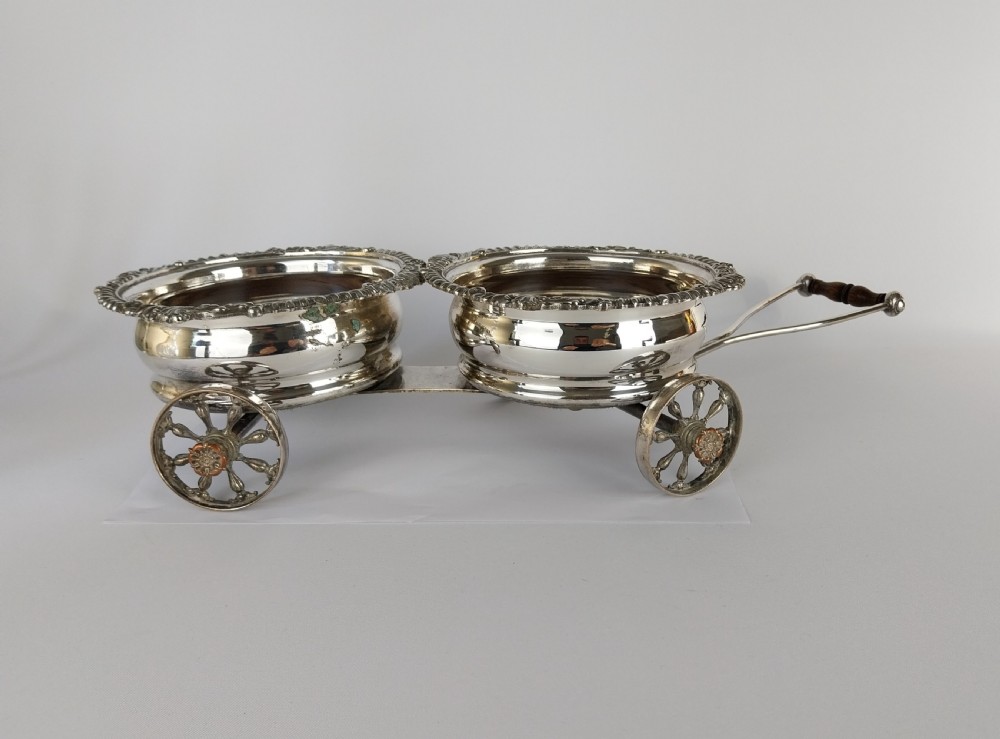 Victorian silver-plated double wine bottle trolley featuring two gadrooned coasters mounted on a wheeled frame with a long handle. View XXX