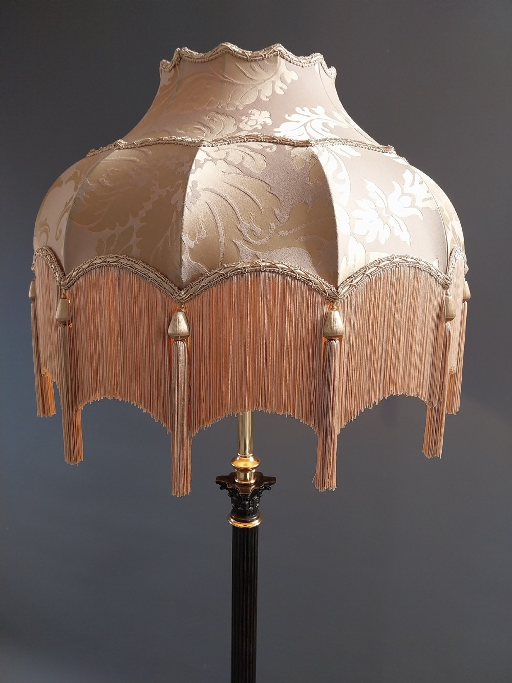 An antique Neoclassical gilt bronze floor standard lamp featuring a fluted dark column, Corinthian capital, stepped square plinth base on claw feet, and a cream fringed shade. View III