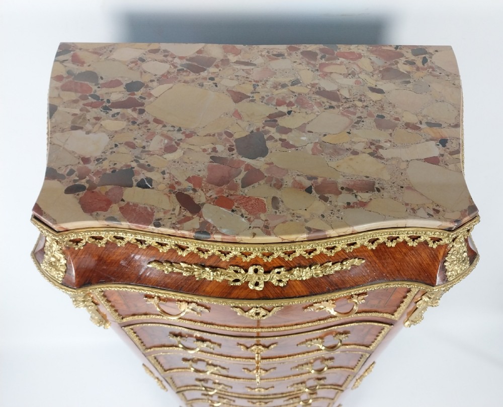 A tall 19th-century French semainier chest of drawers featuring wood marquetry veneer, ornate gilt bronze mounts, seven stacked drawers, and a marble top. View VII