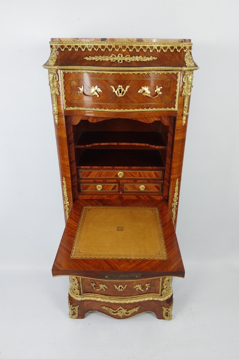 A tall 19th-century French semainier chest of drawers featuring wood marquetry veneer, ornate gilt bronze mounts, seven stacked drawers, and a marble top. View XIII