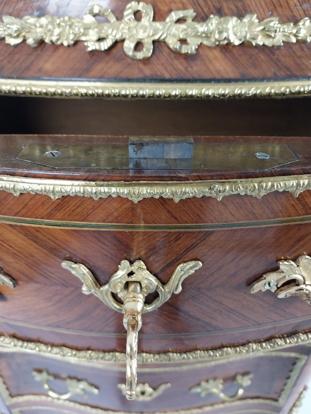 A tall 19th-century French semainier chest of drawers featuring wood marquetry veneer, ornate gilt bronze mounts, seven stacked drawers, and a marble top. View XVI