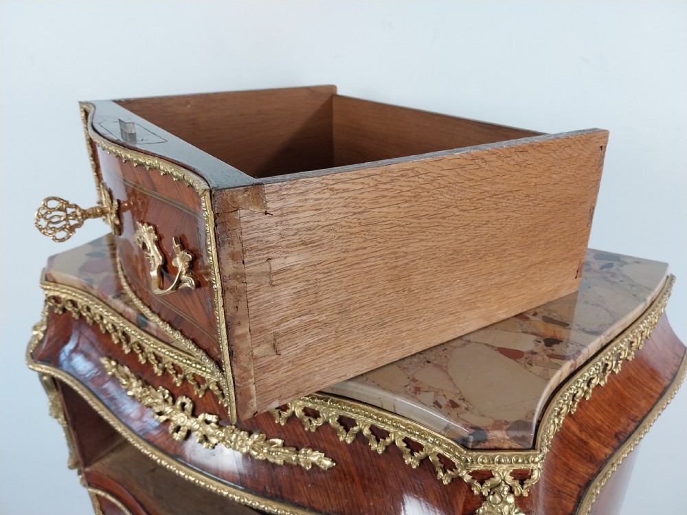 A tall 19th-century French semainier chest of drawers featuring wood marquetry veneer, ornate gilt bronze mounts, seven stacked drawers, and a marble top. View XVII