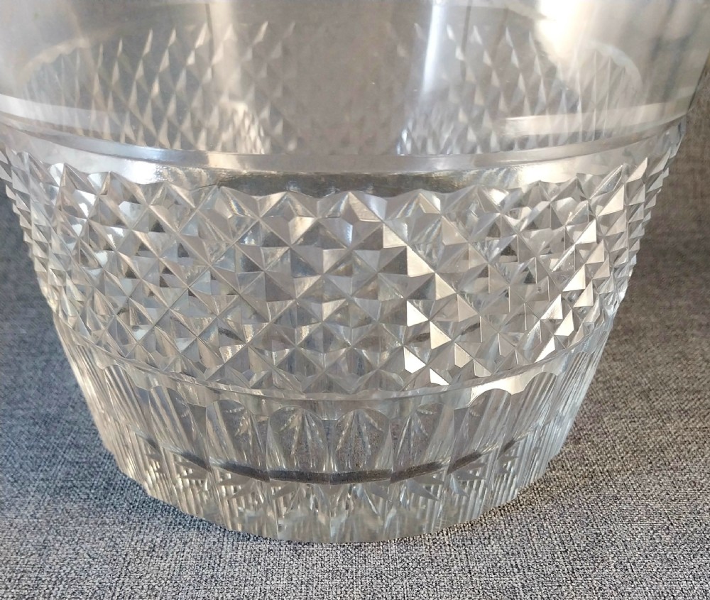 A clear cut glass champagne cooler with etched grapevine detailing, diamond-faceted lower glass, and gilt bronze lion-head ring handles. View VIII
