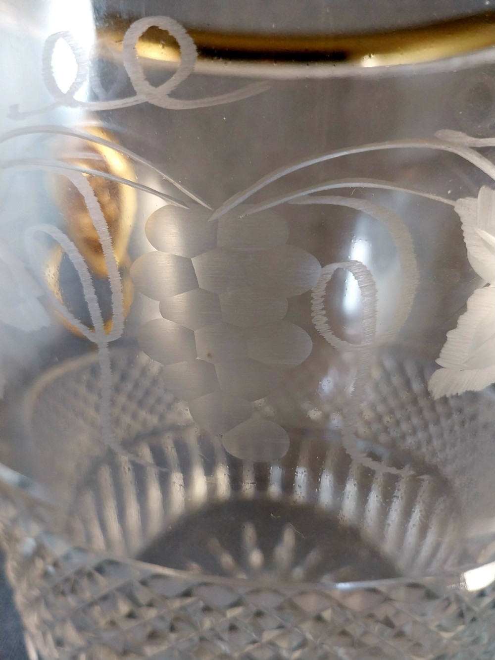 A clear cut glass champagne cooler with etched grapevine detailing, diamond-faceted lower glass, and gilt bronze lion-head ring handles. View XI