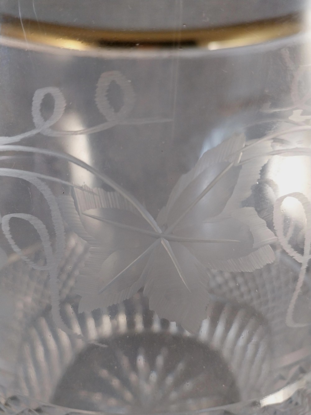 A clear cut glass champagne cooler with etched grapevine detailing, diamond-faceted lower glass, and gilt bronze lion-head ring handles. View XXX