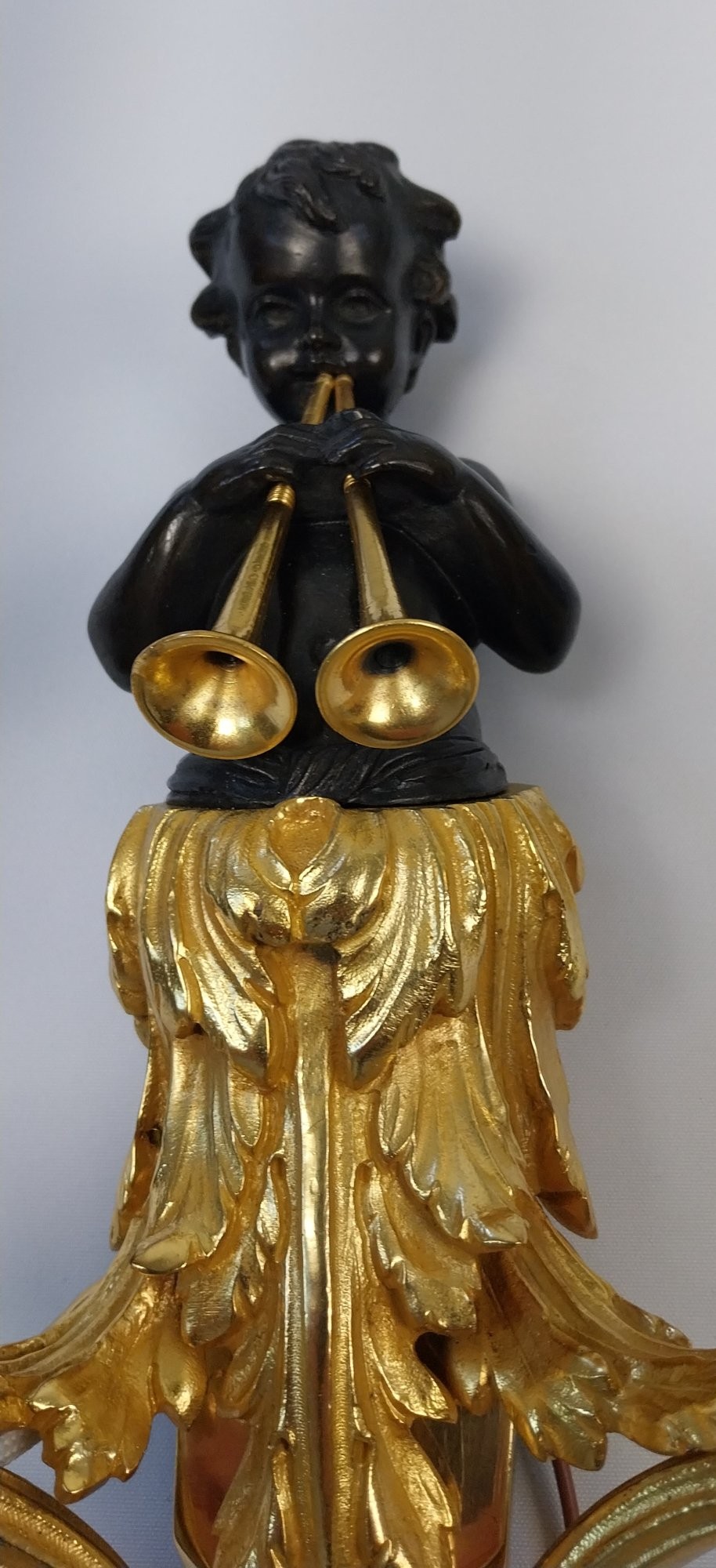 A pair of French gilt and dark patinated bronze two-branch wall sconces featuring central figures holding musical instruments. View XI