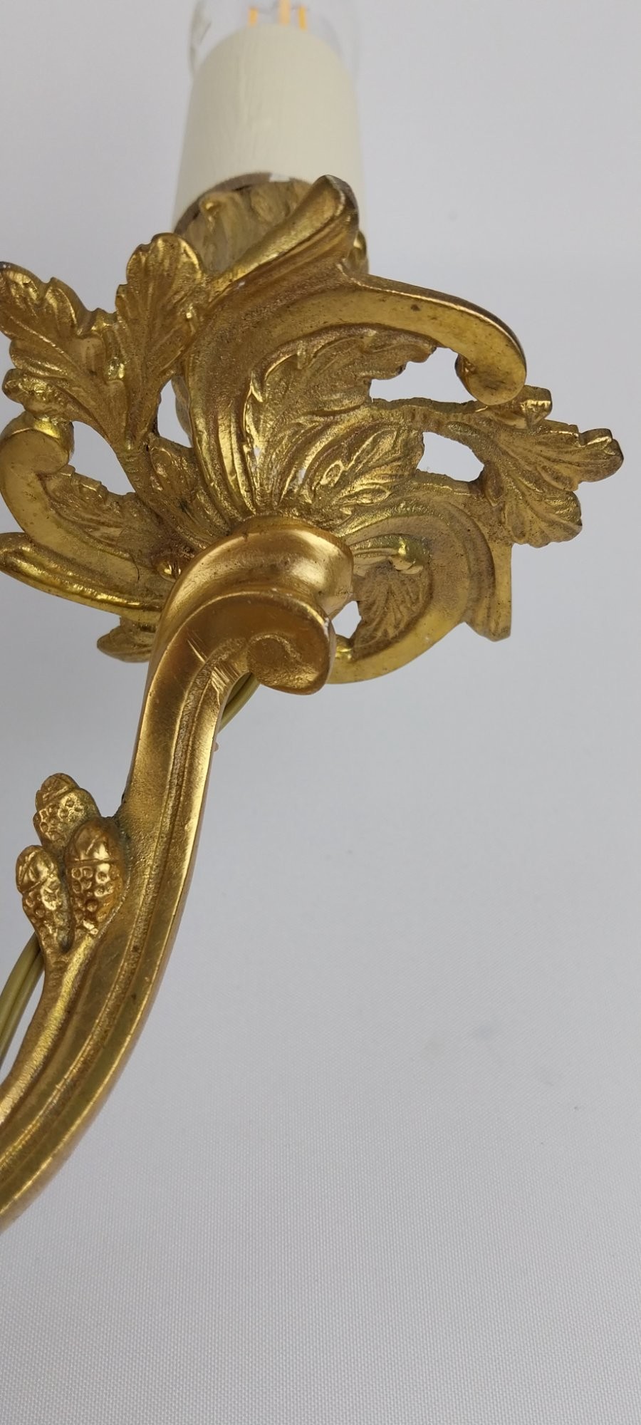 A pair of French Rococo style gilt bronze two-arm wall sconces featuring scrolling acanthus leaf backplates and candle-style sockets. View VI