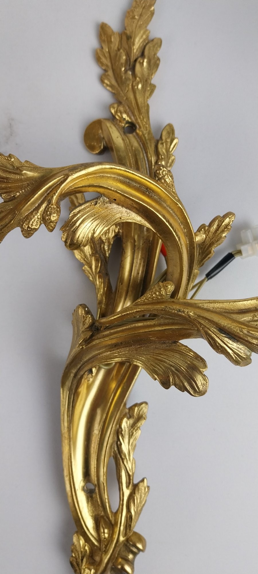 A pair of French Rococo style gilt bronze two-arm wall sconces featuring scrolling acanthus leaf backplates and candle-style sockets. View VII