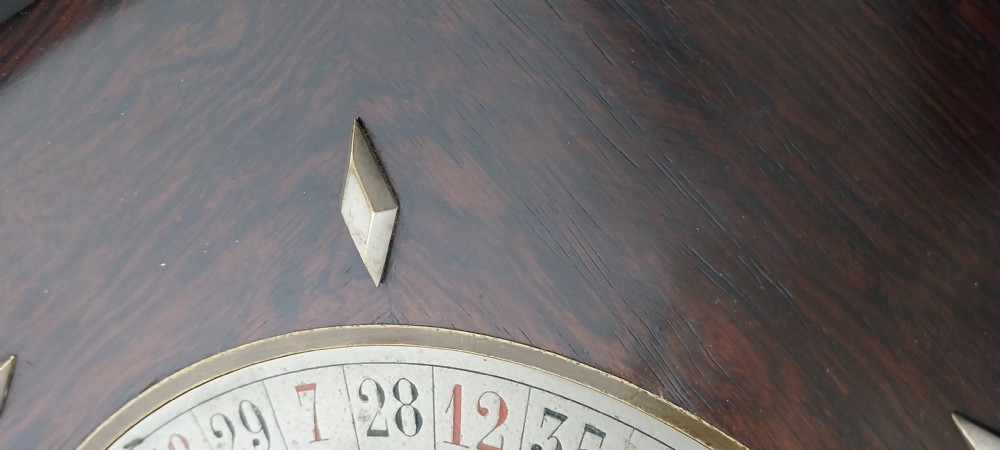 An antique circular rosewood roulette wheel featuring a turned metal central turret and inlaid diamond markers. View XI