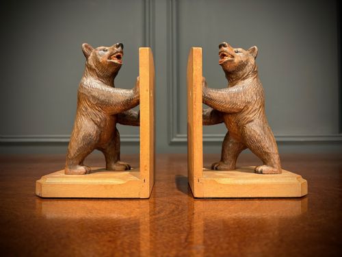 fig 1. A pair of hand-carved wooden bookends depicting standing bears with open mouths pushing against vertical wooden supports.