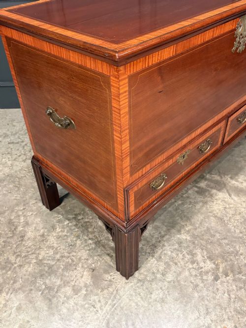 fig 2. A Georgian inlaid mahogany silver chest on stand featuring satinwood crossbanding, brass side carrying handles, two lower drawers, and square legs with bracket corner supports.